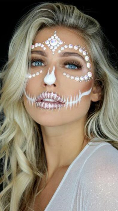 Chica con maquillaje de Catrina en colores blancos con perlas