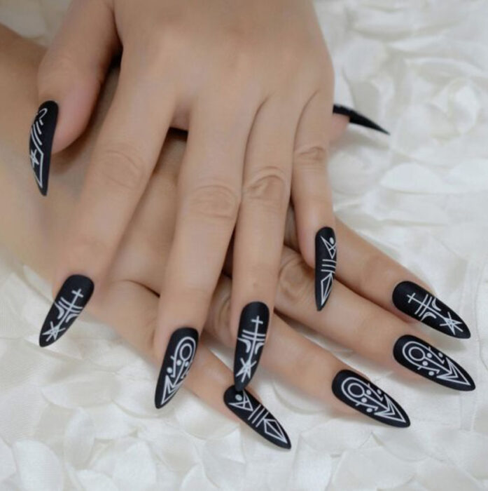 Manicura inspirada en noche de brujas de fondo negro con detalles en blanco