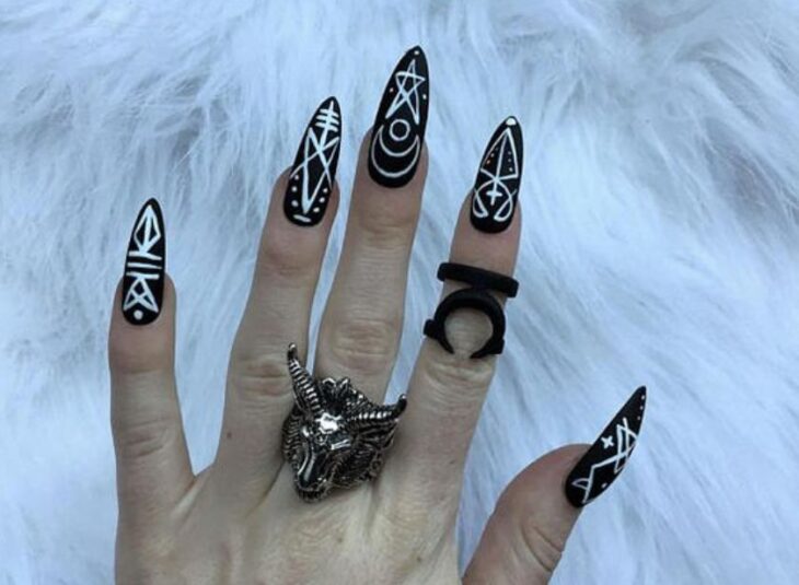 Manicura inspirada en noche de brujas de fondo negro con detalles en blanco