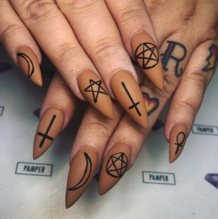 Manicura inspirada en noche de brujas de fondo café, con detalles en negro