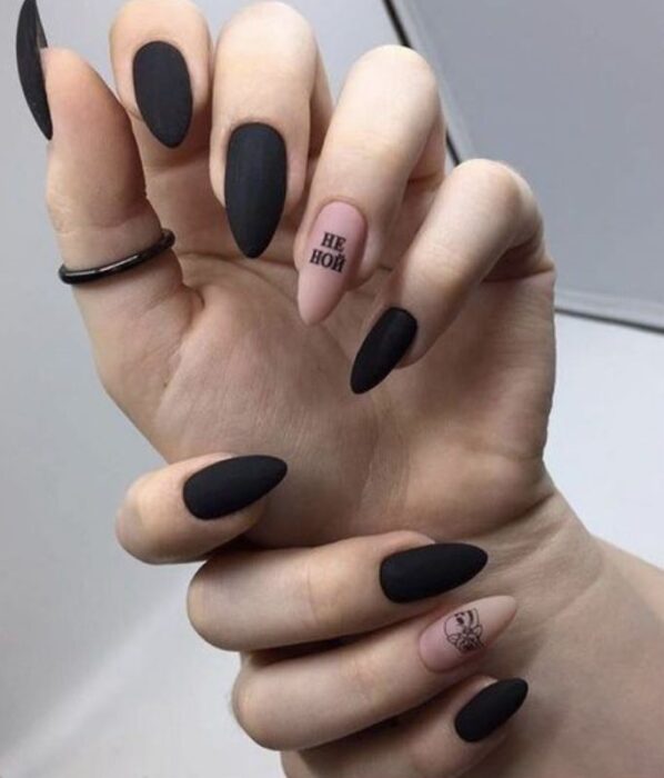 Manicura inspirada en noche de brujas de color negro con uno en nude y detalles en negro