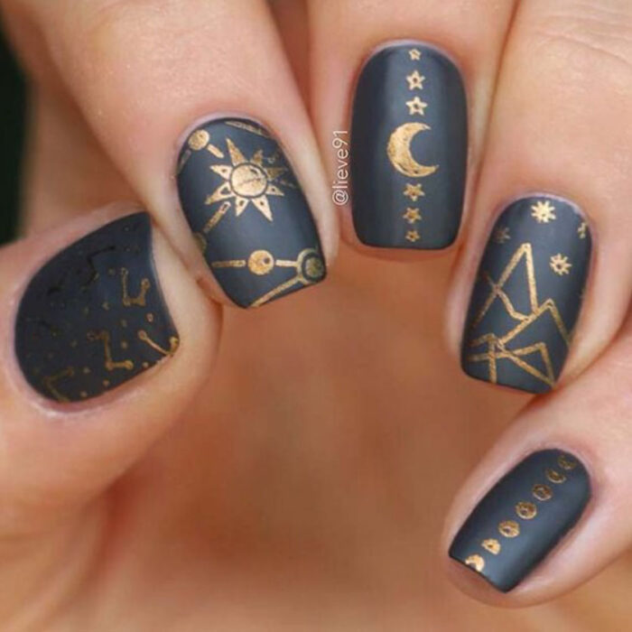 Manicura inspirada en noche de brujas de fondo negro con detalles dorados