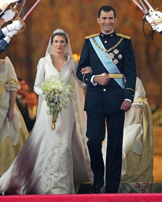 Letizia de España el día de su boda luciendo un vestido blanco de encaje con un ramo de novia con flores blancas