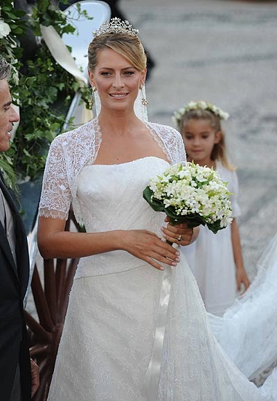 Tatiana Batnik el día de su boda luciendo un vestido blanco de encaje con un ramo de novia con flores blancas