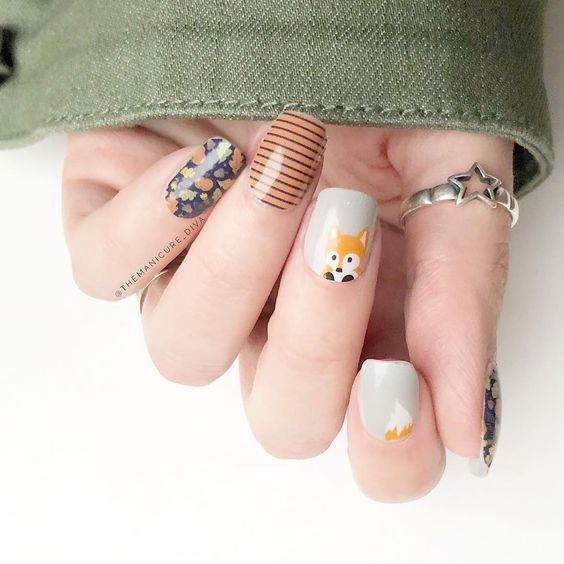 Manicura en colores otoñales con dibujo de un pequeño zorro