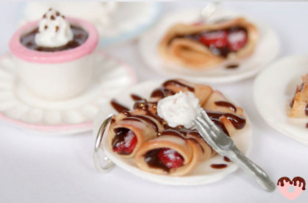 Pequeños aretes en forma de crepas rellenas de mermelada de fresa y helado