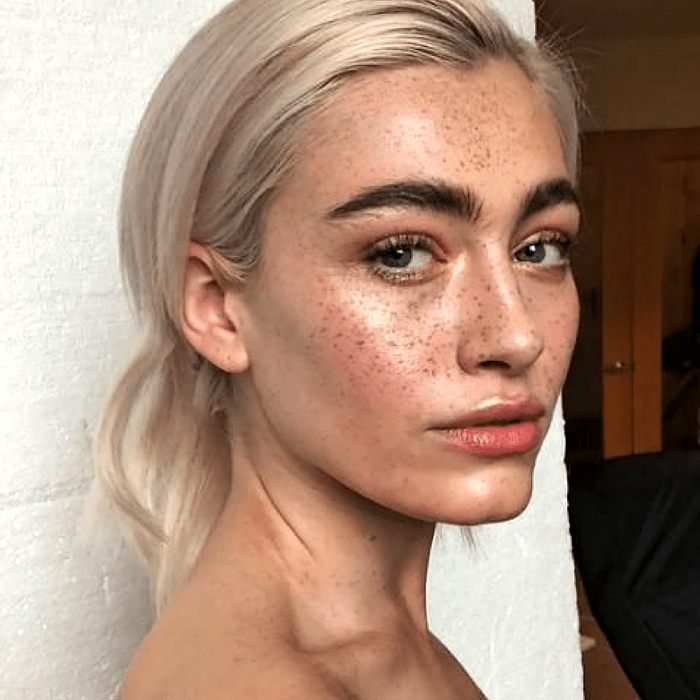 chica rubia platinada con maquillaje editorial natural con pecas