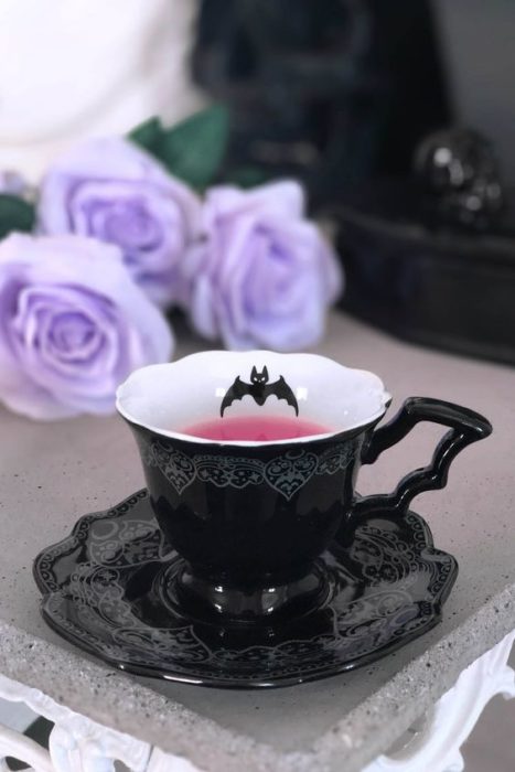Taza negra con un mango en forma de ala de murciélago