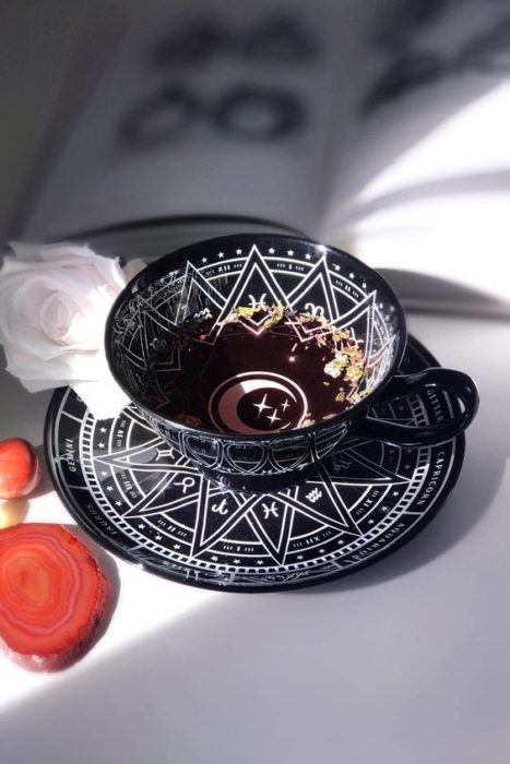 Taza negra decorada con signos zodiacales
