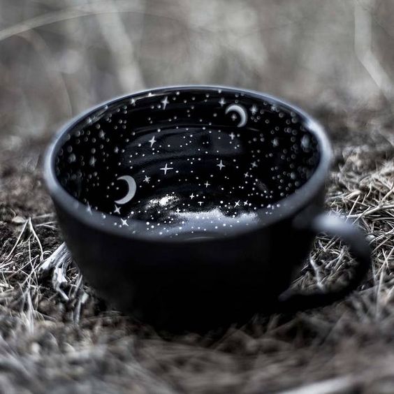 Taza negra con interior estrellado y una luna blanca