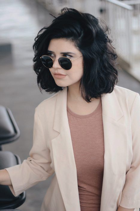 Chica con cabello corto color negro con mucho volumen medio ondulado