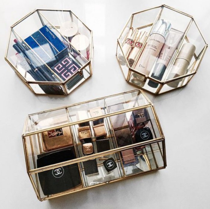 Organización de maquillaje y skin care en contenedores de cristal con armazón de metal