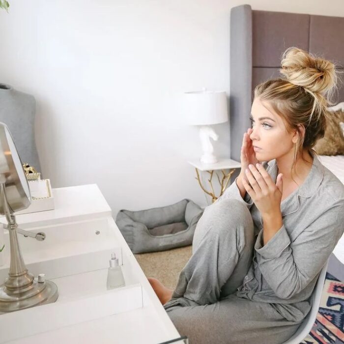 Chica frente al espejo revisando su piel sin imperfecciones
