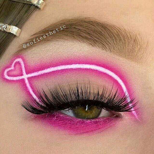Chica con un maquillaje de ojos en tonos rosados con efecto neón