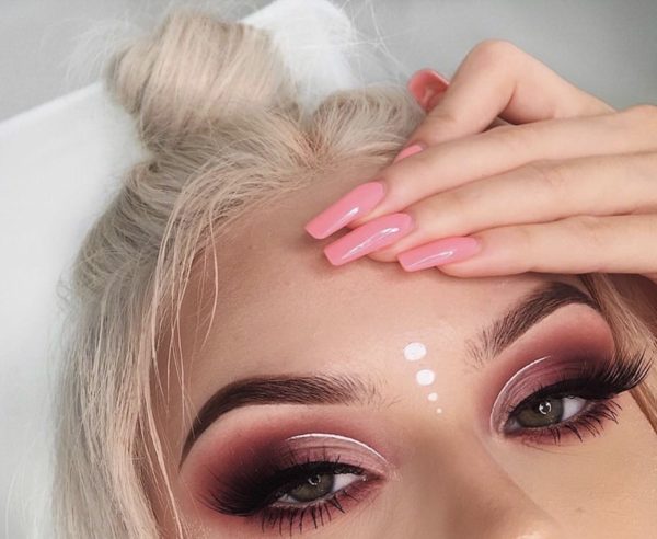 Chica con un maquillaje de color rosa con un smoky eye y un delineado de color plateado