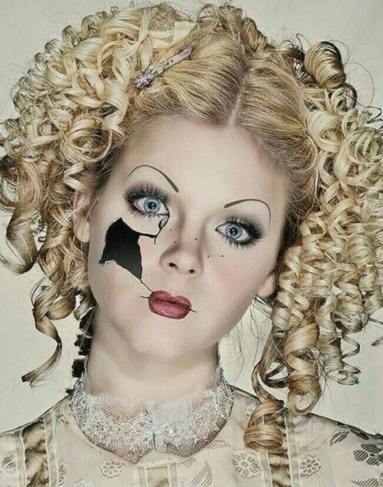 Chica con un maquillaje y peinado de Halloween como el de una muñeca