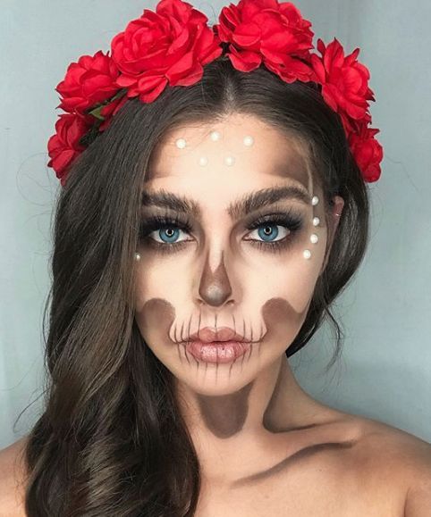 Chica con maquillaje de Catrina usando una corona de rosas rojas