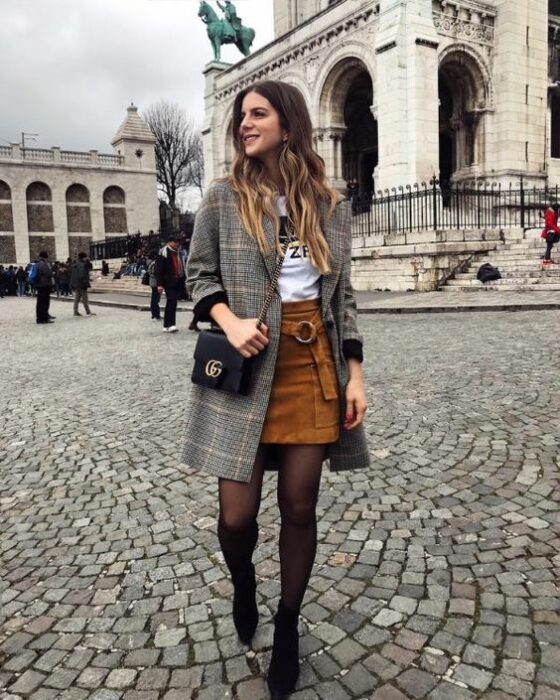 Outfit para la oficina de otoño-invierno de abrigo gris, blusa blanca, minifalda color camel, medias y botines negros