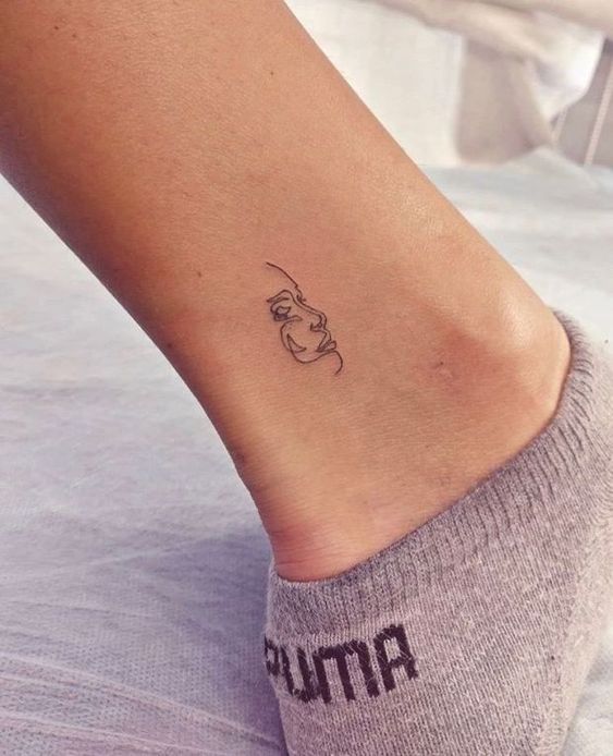 Tatuaje en el tobillo en forma de silueta de rostro