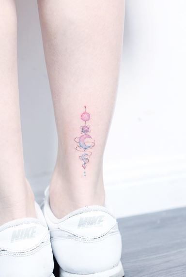 Tatuaje en el tobillo con planetas de colores