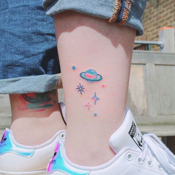 Tatuaje en el tobillo con planetas de colores fluorescentes