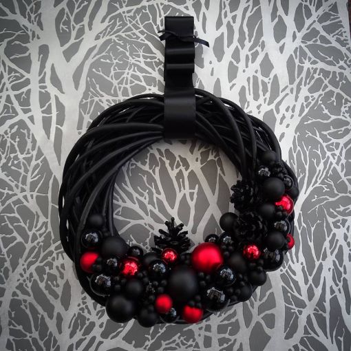 Corona navideña decorada en tonos negros y rojos