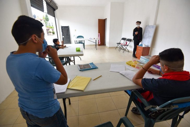 Chico dando clases en un pequeño salón en la Ciudad de México