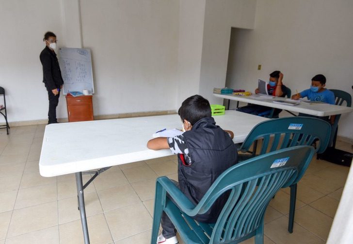 Chico dando clases en un pequeño salón en la Ciudad de México