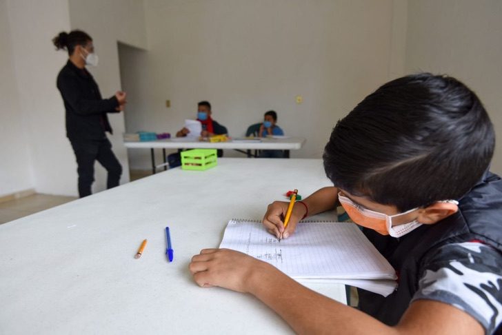 Niño tomando clases en un pequeño salón de clases improvisado