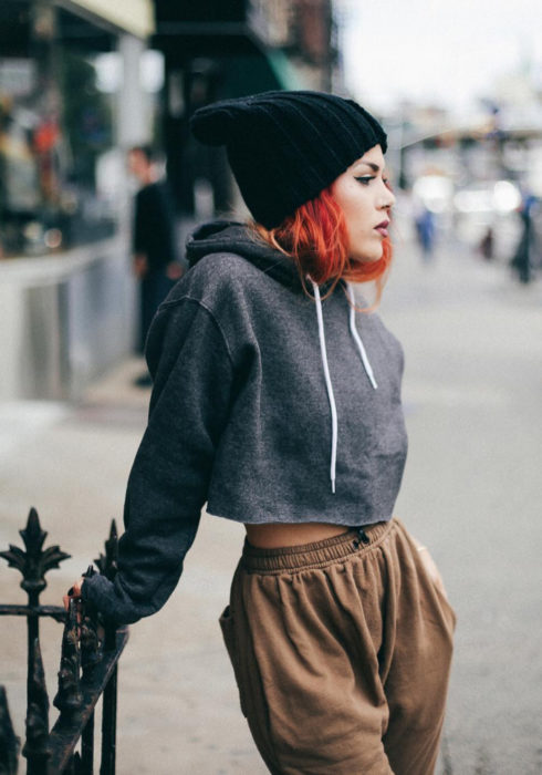Looks con sudadera; chica pelirroja con estilo urbano, hoodie crop top gris oscuro, gorro tejido de frío, pants café