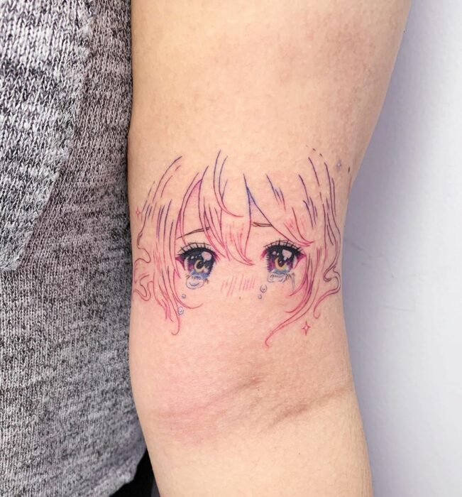 Chica con un tatuaje de color rosa en forma de carita de muñeca