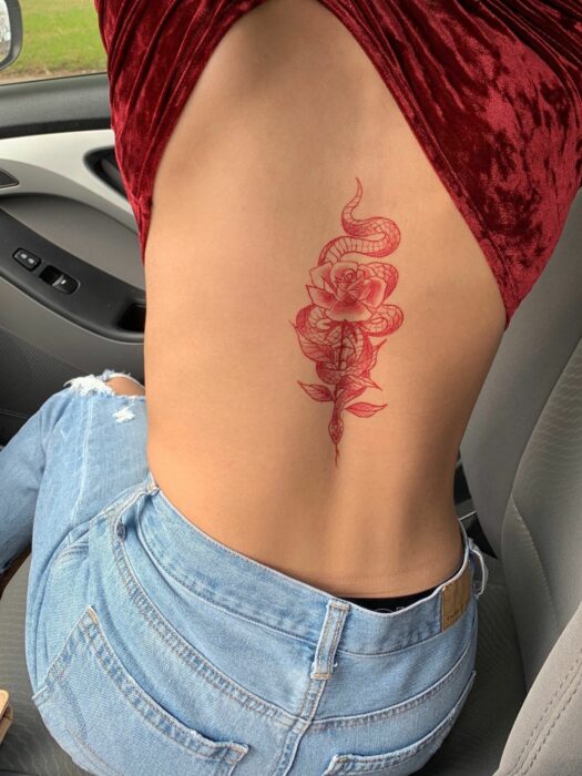 Chica con un tatuaje de color rosa en forma de flores