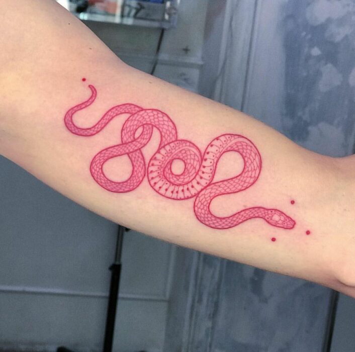Chica con un tatuaje de color rosa en forma de serpiente