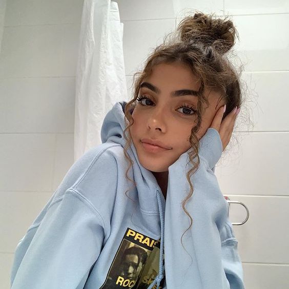 chica con bun alto y rizos al frente