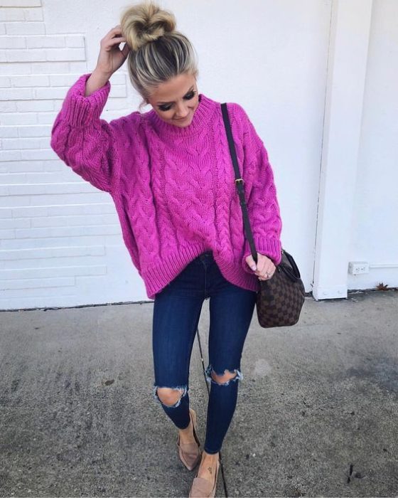 Chica usando suéter holgado color fucsia, jeans rasgados y flats
