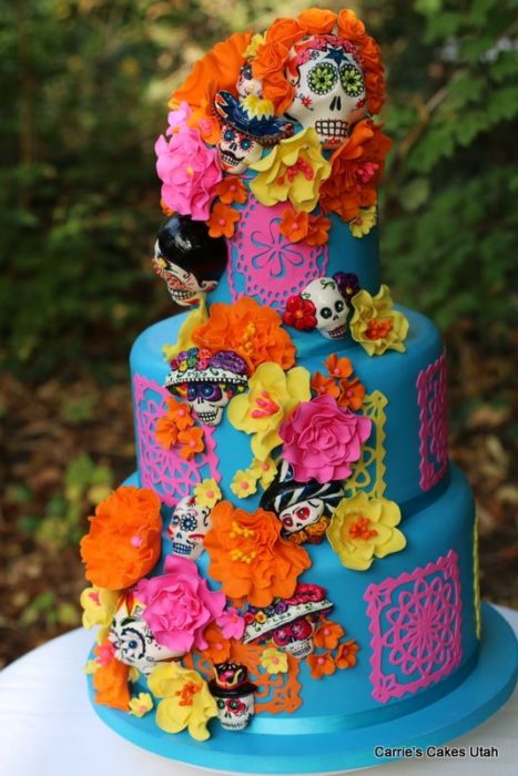 Pastel inspirado en el Día de muertos de tres pisos en color verde con flores de betún