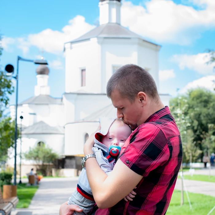 Hombre paseando junto a su hijo y besándolo en la frente 