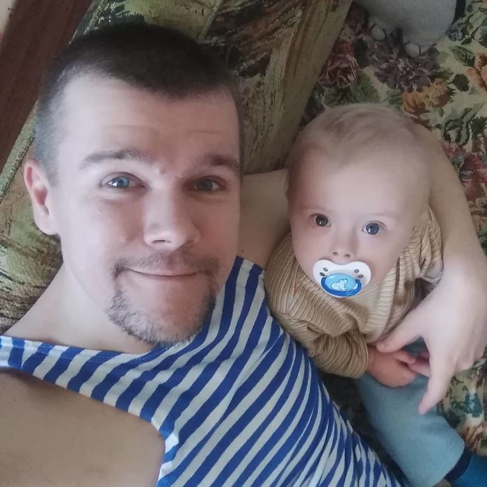Hombre tomándose una selfie mientras está junto a su pequeño hijo 