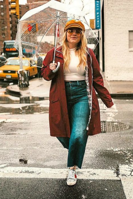 Chica curvy usando tenis, pantalones rectos verdes, top blanco y chaqueta color vino
