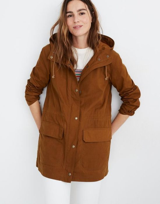 Chica usando jeans y blusa blancas con un anorak color camel