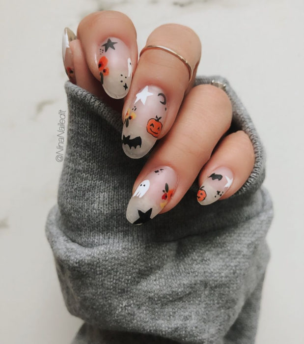 Diseños de uñas largas de almendra kawaii, tiernas de Halloween en colores pastel; murciélagos, calabazas, fantasmas y estrellas