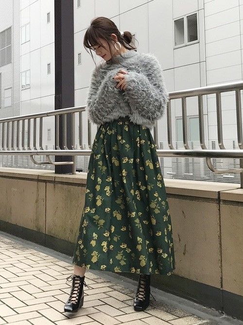 Chica asiática con suéter gris y falda verde con flores