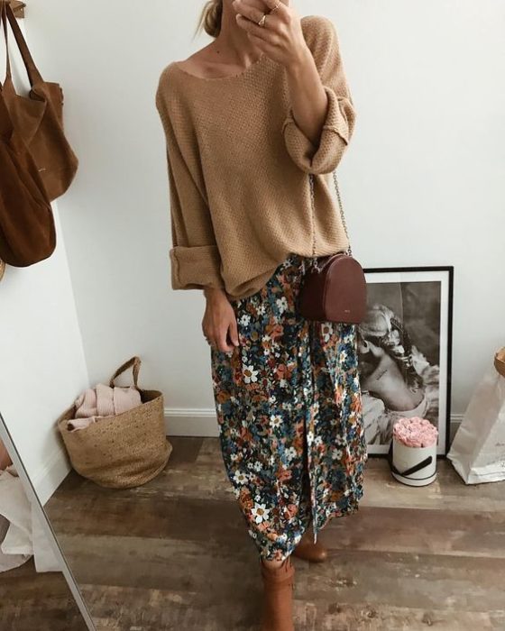 Chica tomándose un selfie frente al espejo con suéter oversized café y falda de flores color verde