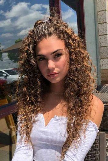 Chica con cabello rizado y una media coleta