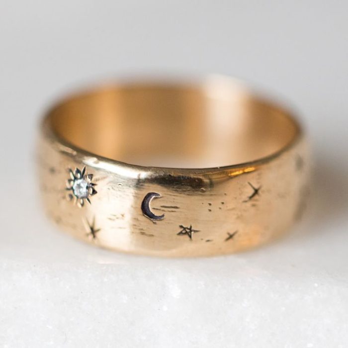 Anillo dorado con tallados de estrellas, luna y soles