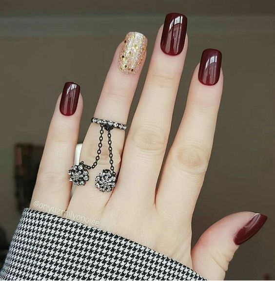Manicura en tonos vino con dorado