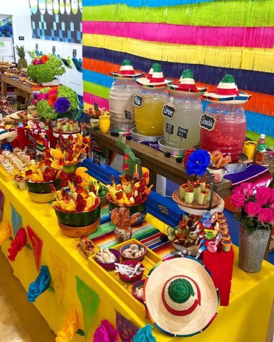 Mesa de dulces mexicanos con frutas y aguas frescas