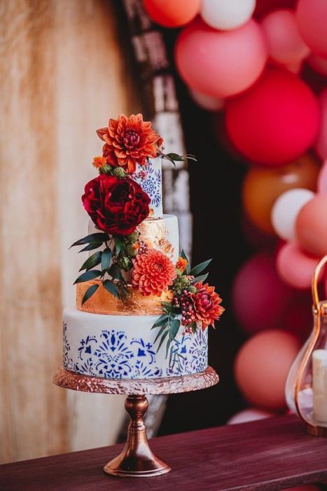 Pastel blanco con detalles azules y flores mexicanas