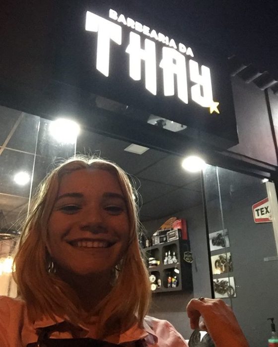Thayssa tomando una selfie afuera de su barbería