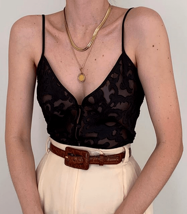 blusa de tirantes con encaje y cinturón café de piel, pantalón de vestir beige y collares de oro